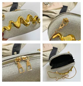 Glänzende silberne Umhängetasche für Damen mit schickem goldenem Wellenmetall-Akzent und Kette.