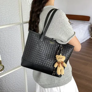 Black woven tote bag for women, large capacity shoulder bag with cute bear pendant and top handles.