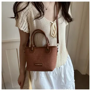 Brown woven bucket bag detail showing stylish top handle and crossbody strap design.