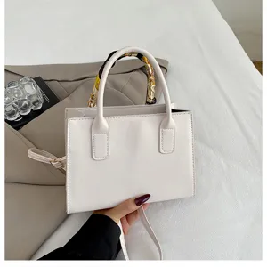 White leather top handle shoulder bag with stylish printed silk scarf detail for women.