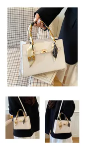 Chic white leather handbag featuring a stylish printed silk scarf wrapped around the top handle.