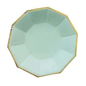 Gros plan détaillé de l'assiette en carton décagonale vert menthe avec bordure dorée.