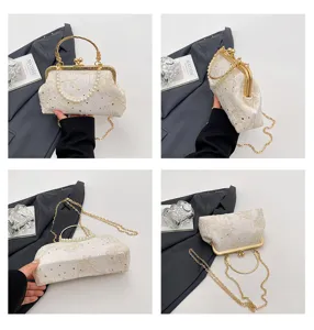 Detail view of retro white lace evening bag with gold metal frame and pearl handle.