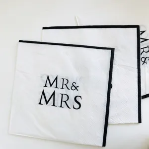 White paper napkins featuring black borders and MR & MRS print, perfect for wedding party decor.