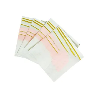 Disposable paper napkins set with pink brush strokes and gold foil lines for party.