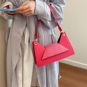 Pink asymmetric crocodile texture crossbody shoulder bag detail view, trendy fashion handbag.