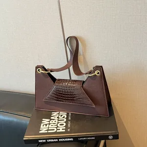 Stylish brown structured shoulder bag with chic crocodile embossed flap and metal rings.