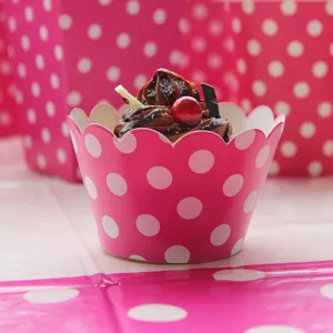 Pink polka dot cupcake wrapper and party supply, perfect for birthday celebrations and events.