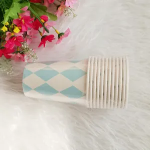 Detailed view of disposable paper cups with blue diamond pattern for party tabletop decor.