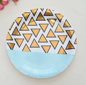 Nahaufnahme eines Einwegpapptellers mit metallischen goldenen geometrischen Dreiecken.