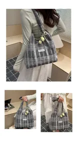 Detail view of Korean style plaid tote bag, featuring a cute pearl and tulip pendant, casual.