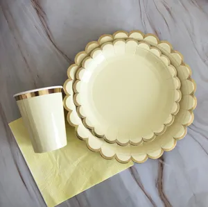 Disposable paper tableware set with gold foil scalloped plates and cups for birthday party.