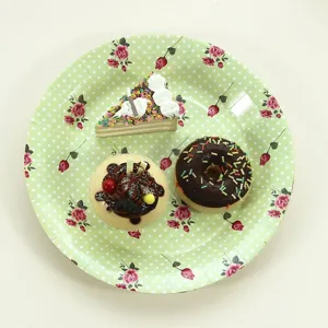 Assiettes en carton jetables à pois verts et roses pour le thé et les fêtes de famille.