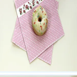 Pink polka dot paper napkins with rose floral border for children's birthday party decor.