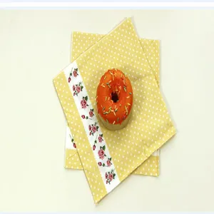Details of yellow polka dot paper napkins with rose floral pattern for party decoration use.