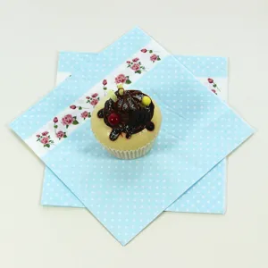 Blue polka dot paper napkins with rose floral pattern for kids birthday party table decor.