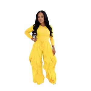 Yellow two-piece set featuring a slim long-sleeve top and ruffled wide-leg pants for women.