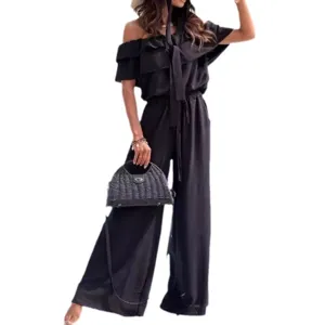 Tuta elegante donna nera con spalle scoperte volant patchwork vita alta gamba larga