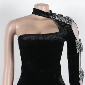 Detail view of a sexy black velvet one-sleeve bodycon dress with rhinestone crystal bows.