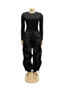 Black two-piece outfit featuring long sleeve top and ruched wide-leg pants for women.