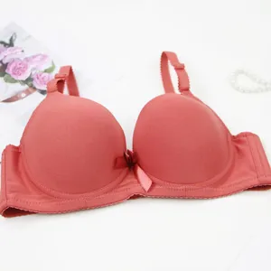 Detail view of women seamless push up bra in solid pink, smooth surface design and cute bow.