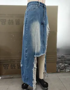 Detailed view of irregular raw edge distressed denim skirt, high waist street fashion style.