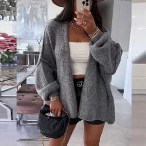 Detail shot of oversized gray knit cardigan featuring cozy V-neck and relaxed fit style.