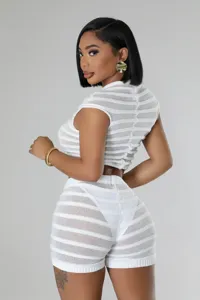 Close-up detail of the white knitted two-piece crop top and shorts set, textured fabric.