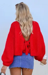Vista di dettaglio del maglione rosso in grossa maglia da donna con retro aperto e fiocco.