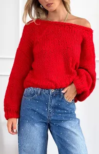 Vista di dettaglio del maglione rosso in grossa maglia con spalle scoperte e tessuto.
