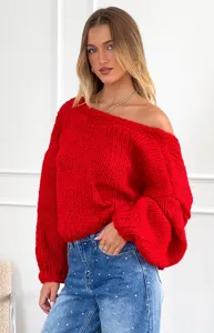 Maglione rosso in grossa maglia con spalle scoperte in dettaglio, tessuto morbido ed elegante.