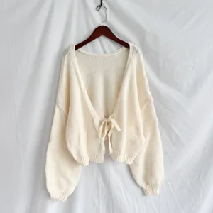 Cardigan in maglia crema con dettaglio fiocco sul davanti, capo corto chic ed elegante.