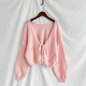 Dettaglio cardigan in maglia rosa, scollo a V con grazioso fiocco, tessuto morbido.