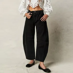 Detail view of casual loose black denim trousers featuring a stylish curved barrel leg design.