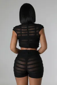 Back view detail of black sheer knit two piece crop top and high waist shorts set.