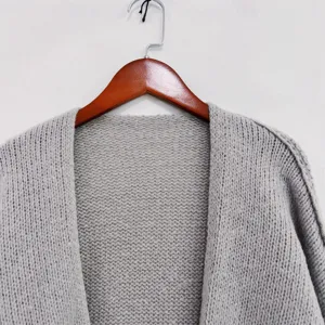 Close up detail of women grey knit cardigan sweater, casual V-neck autumn winter knitwear.