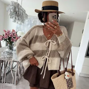 Detailed view of women's cozy color-block striped knit cardigan with stylish tie front closure.