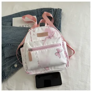Mini white backpack with pink butterfly and calligraphy print, pink straps, casual daily use.