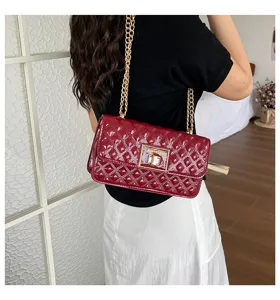 Detailed shot of dark red patent leather quilted shoulder bag with chic gold chain strap.