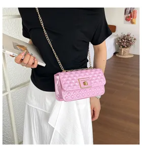 Close-up of pink quilted patent leather shoulder bag with gold chain strap and metal lock detail.