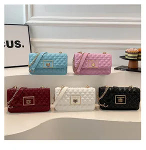 Detailed shot of quilted chain shoulder bags in multiple colors, featuring metallic locks and straps.