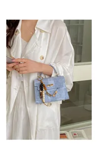 Gros plan détaillé du sac bandoulière bleu clair avec matériel élégant et charmant pendentif.