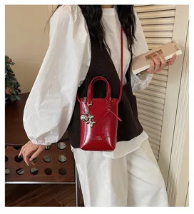 Sac bandoulière rouge en cuir pour femme, petit sac élégant avec joli charm en métal.