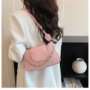 Pink shoulder bag for women stylish star embossed designer purse with chain and braided strap.