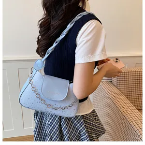Elegante borsa a tracolla azzurra da donna con stampa di stelle e catena decorativa chic.
