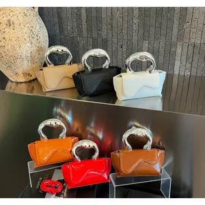 Detailansicht trendiger Mini-Handtaschen mit einzigartigen Metallgriffen in vielen bunten Farben.