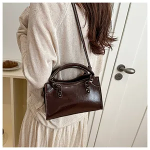 Brown patent leather shoulder bag detail, vintage motorcycle style handbag for women daily wear.