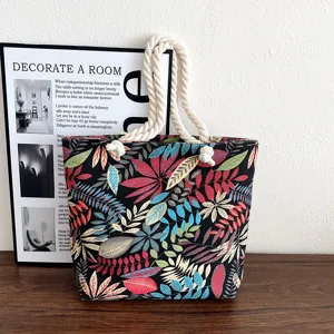 Canvas tote bag detail view, botanical leaf print pattern, thick rope handle, casual style.
