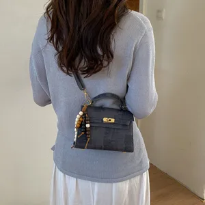 Vue détaillée du sac à bandoulière pour femme élégant avec un pendentif charmant.
