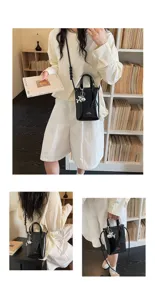 Sac de téléphone noir en PU pour femme sac bandoulière vertical avec lanière tressée.